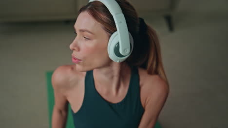 sport woman listening music in headphones at workout close up. girl stretching
