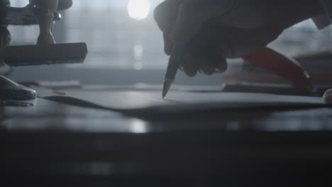 person writing on a document at a desk