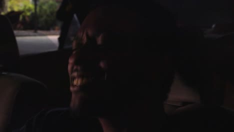 black man jams out to music in parked car, close up