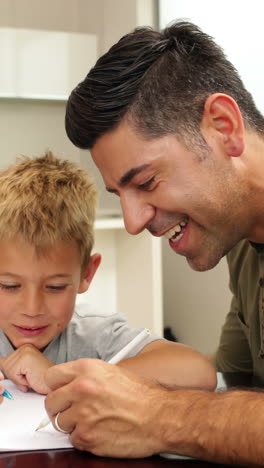 niños dibujando con su padre en la mesa