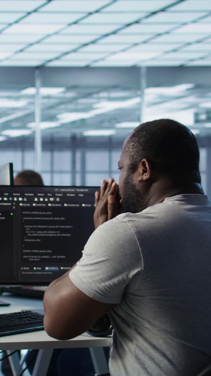 Stressed African American Programmer Working on Code in Office
