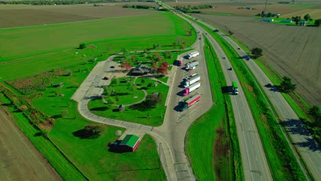 Antena-De-La-Parada-De-Descanso-De-La-Pradera-De-Illini-En-Dirección-Norte,-Los-Camiones-Estacionados-Están-Haciendo-Un-Descanso-Mientras-El-Tráfico-De-Automóviles-Circula-Sin-Problemas-En-La-Carretera-Cercana-A-Ellos