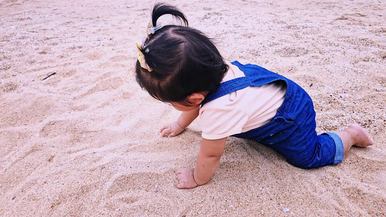 A joyful toddler explores the sandy beach playing and discovering nature's wonders.