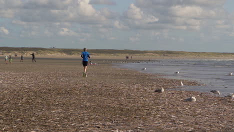 jogger running over beach in slow motion