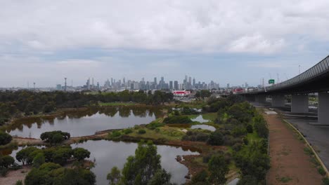 drone volando más allá del lago rosa hacia la ciudad de melbourne
