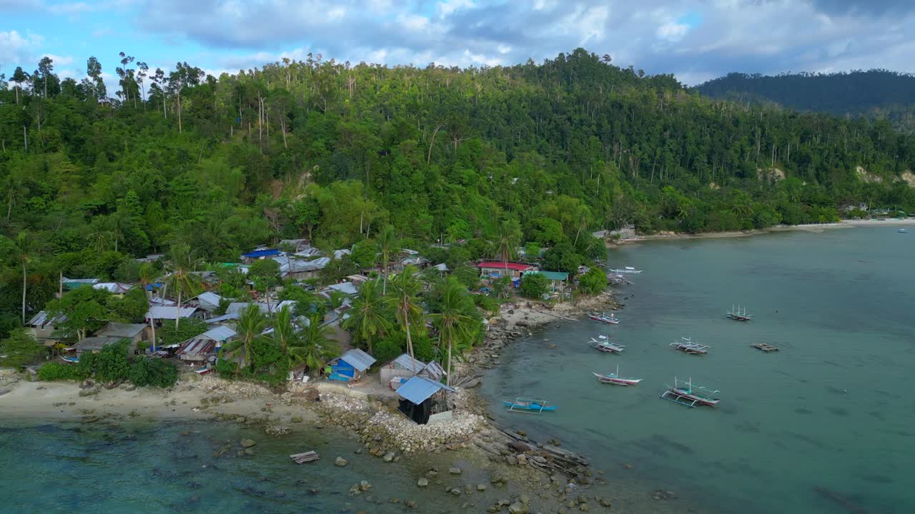 Villaggio di Port Barton, Palawan, Filippine, con barche tradizionali che riposano su acqua cristallina turchese accanto a una spiaggia sabbiosa. Bella veduta aerea panoramica in discesa con drone.