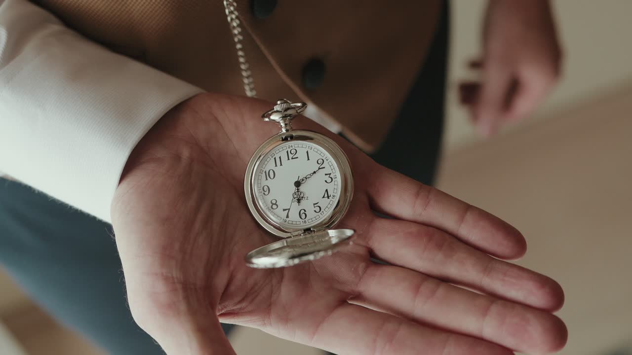 closeup vintage pocket watch resting in an open hand