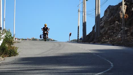 young man drives down vietnamese road with yellow motorcycling helmet