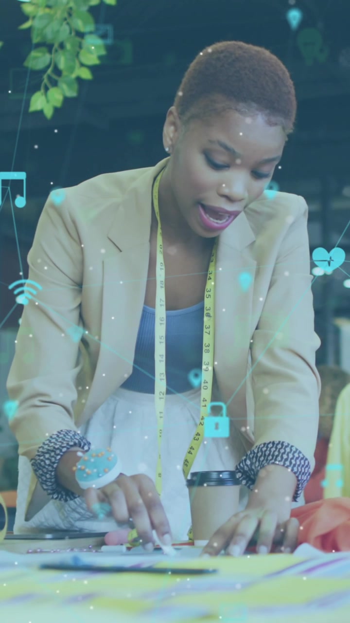 Animation of multiple icons connected with lines over diverse fashion designers discussing ideas