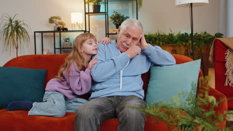 loving worried kind girl granddaughter consoling sad crying grandfather helping with problem at home