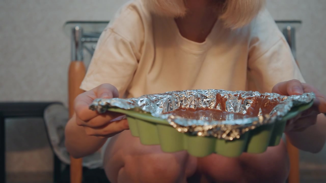 Lowangle oven interior with pastry, white pastry student leaning forward to check browning of foilcovered tray, hands reaching across rack, warm glint on crust, intimate tutorial vibe