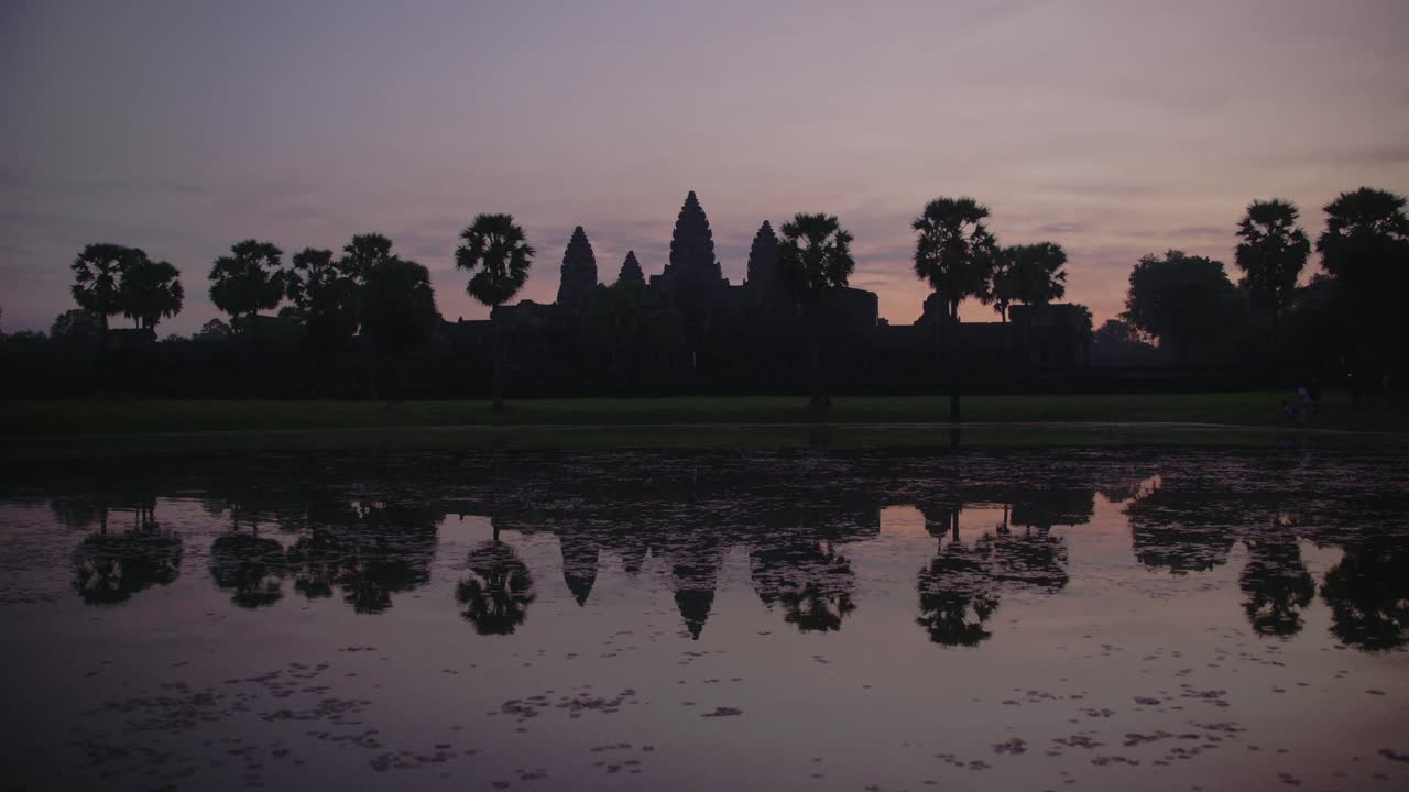 L'aube se lève sur Angkor Wat avec un ciel éclatant se reflétant dans l'eau, serein et majestueux, timelapse