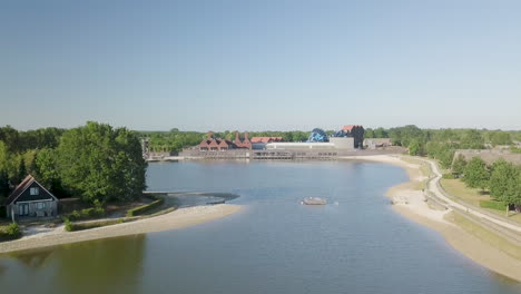 Panorama-Drohneansicht-Von-Menschen,-Die-Auf-Einer-Plattform-Im-See-Eines-Ferienparks-In-Den-Niederlanden-Baden