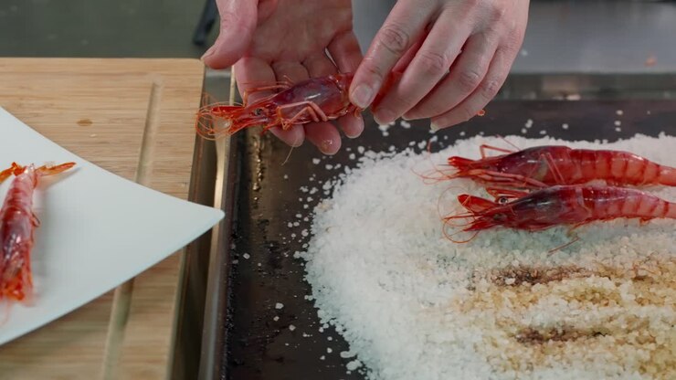 Serving a grilled red shrimp on salt