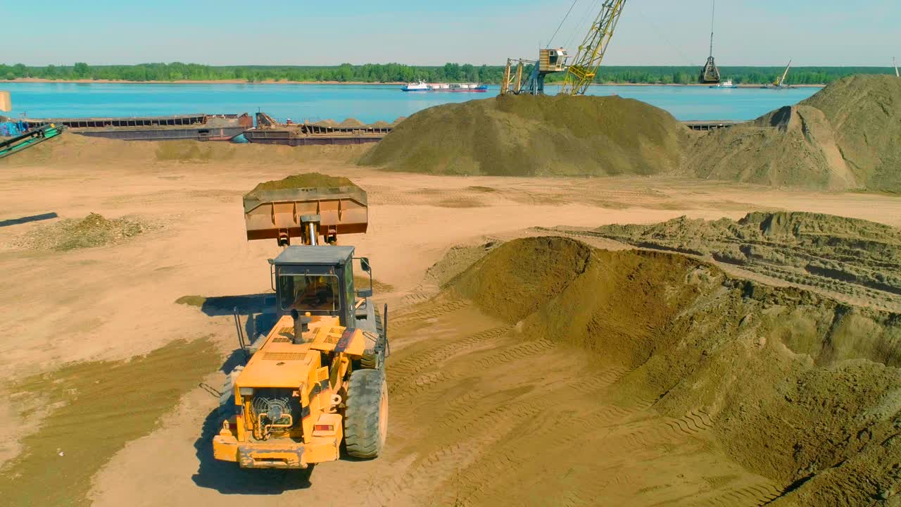 강 항구 에서 모래 를 실고 있는 발굴기