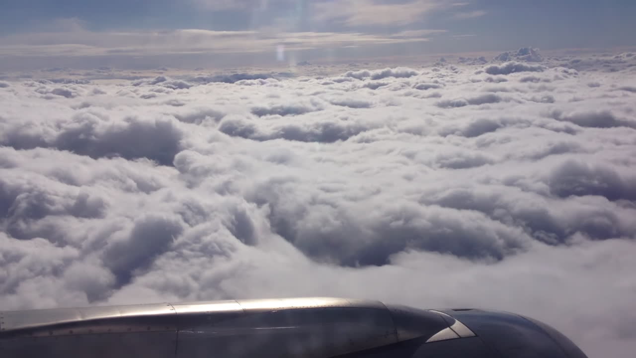 Flying Above Clouds. Cinematic View From Passenger Seat Over Aiplane Engine on Sunny Atmosphere Above Clouds