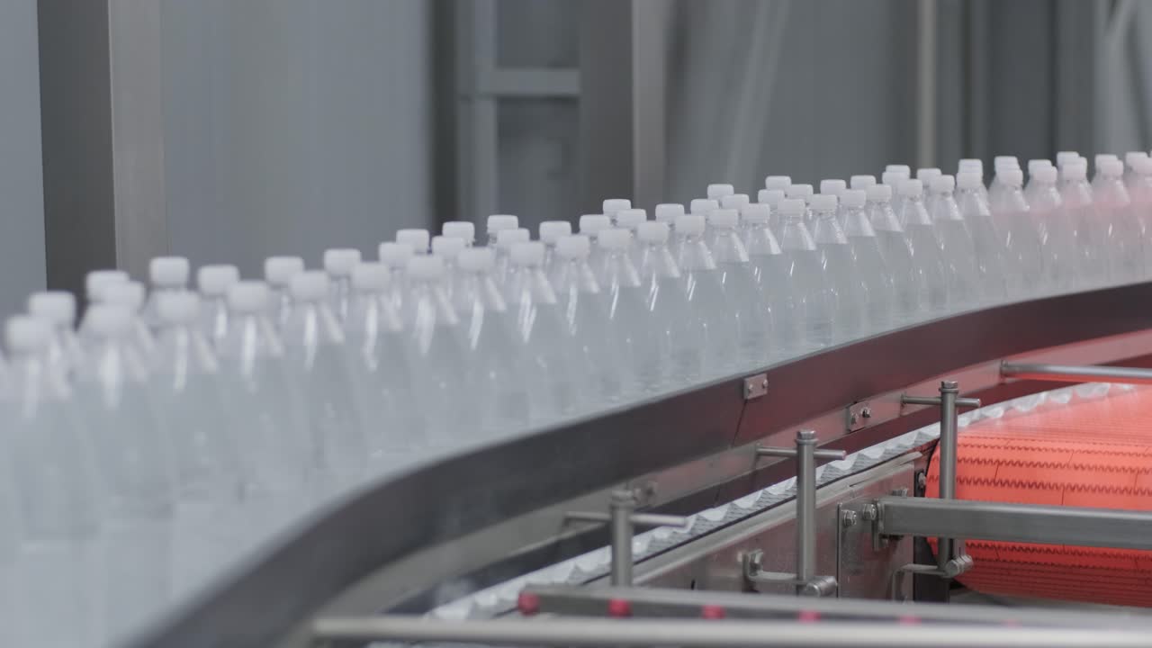 cinta transportadora con botellas de agua potable en una planta de bebidas moderna
