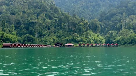 multiple bungalows in a row on the water in khao sok, thailand