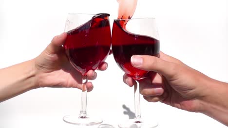 two hands toasting with glass red wine in slow motion on a white background