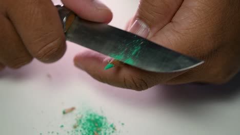 Footage-of-hands-slowly-sharpening-a-pencil-and-some-coloured-pencils-with-a-sharp-knife