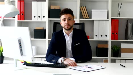 young businessman looking at camera in modern office
