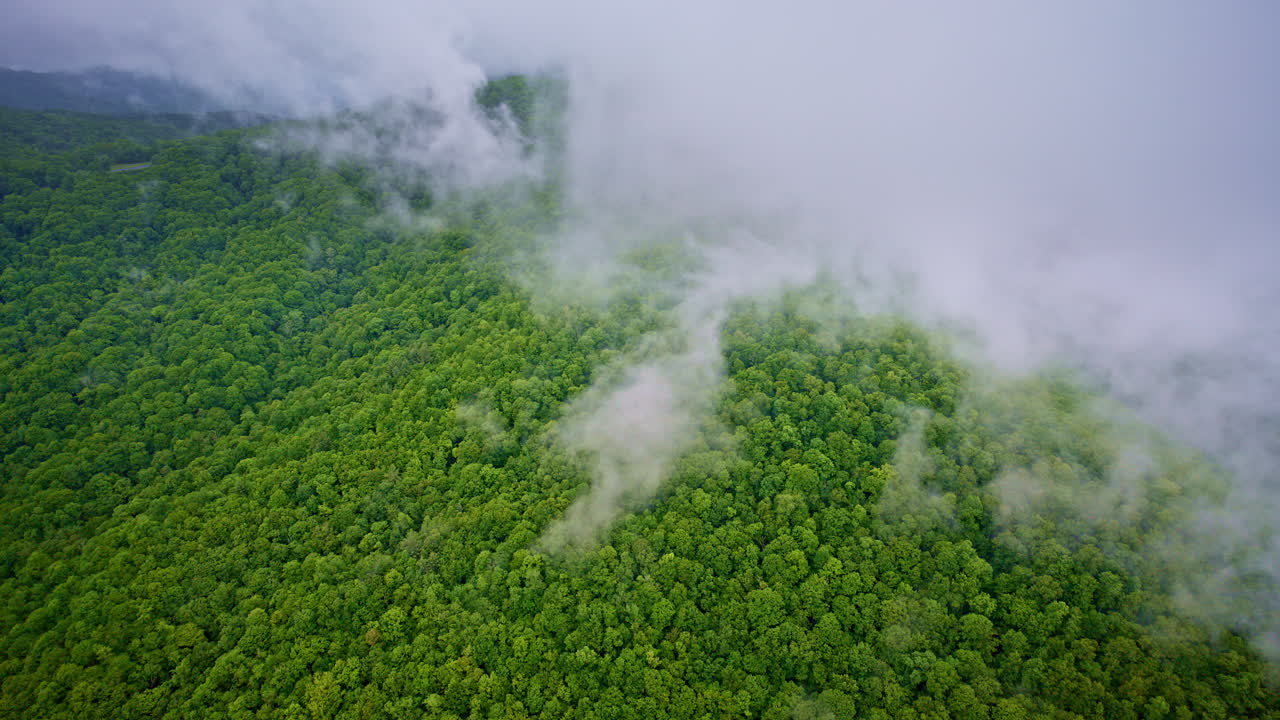 Cinematic glide over hazy, fog-filled mountain tops