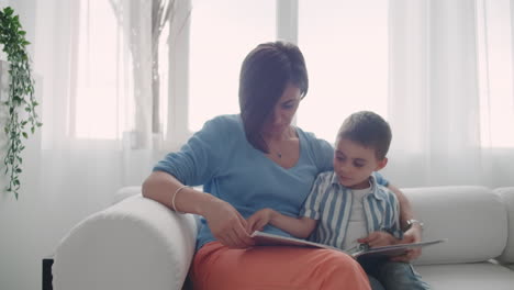 Madre-E-Hijo-Leen-Libros.-Feliz-Joven-Madre-E-Hijo-Leen-Libros-En-El-Sofá-De-Casa