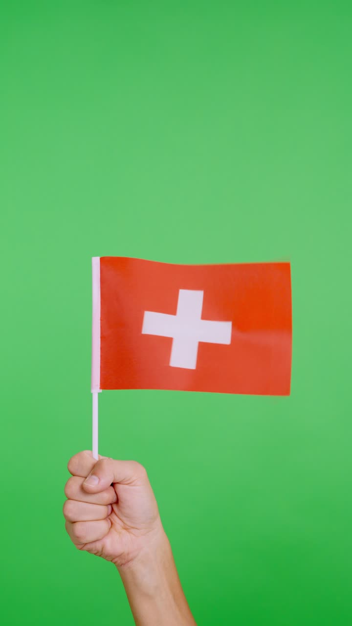Hand lifting a swiss pennant while waving by the wind