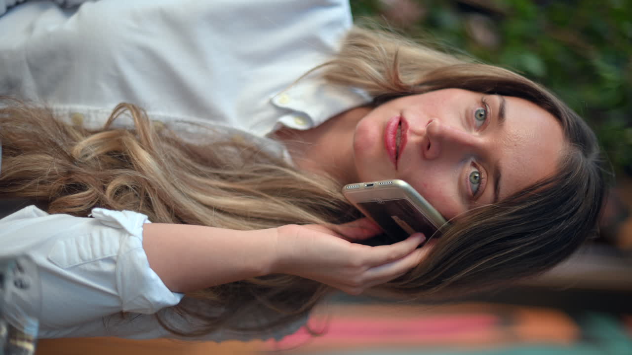 Donna felice che parla al telefono in un ristorante