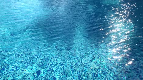 Bright-sunlight-reflecting-and-sparkling-off-the-surface-of-the-water-in-the-swimming-pool