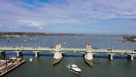 Aerial-4k_Backwards-video-as-boat-crosses-under-Bridge-of-Lions-in-St-Augustine,-Florida,-on-Matanzas-River