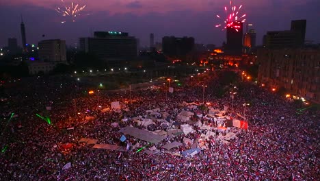 fireworks go off above protestors gathered in tahrir square in cairo egypt at a large nighttime rally 4