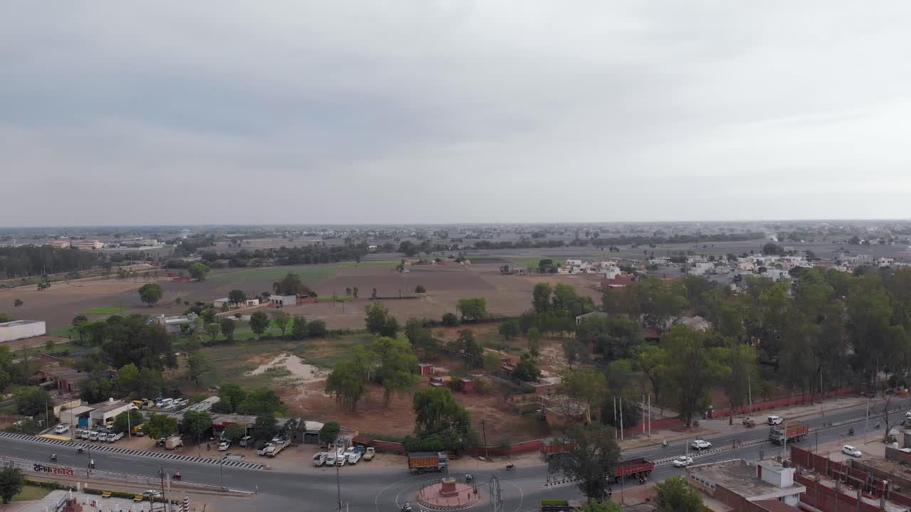 Most Beautiful aerial view of the land in green fields nearby residential area on a cloudy day