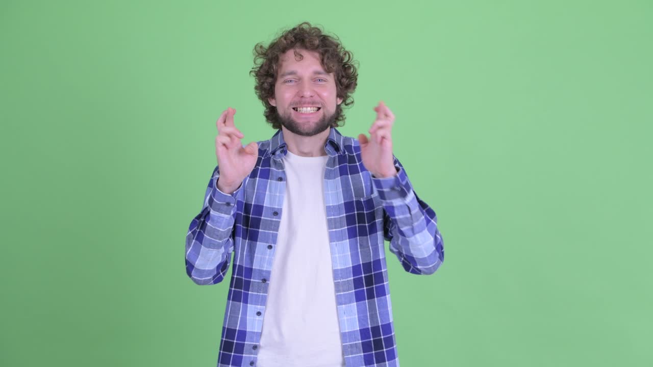 Young handsome bearded hipster man with curly hair