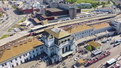 Aerial-view-from-above,-Brno's-Central-Train-Station-on-a-sunny-day,-with-lots-of-people-and-traffic-on-roads