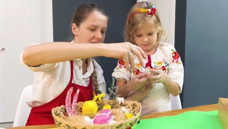 mother and daughter decorating easter eggs