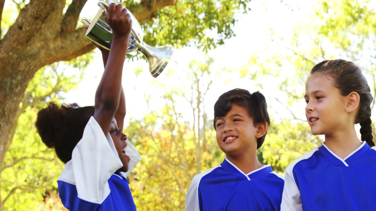 친구 들 에게 트로피 를 보여 주는 소녀