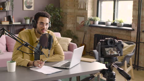 man wearing headphones and talking into a microphone