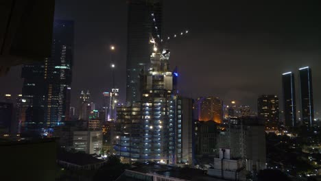 night time illumination jakarta city downtown construction rooftop panorama 4k indonesia