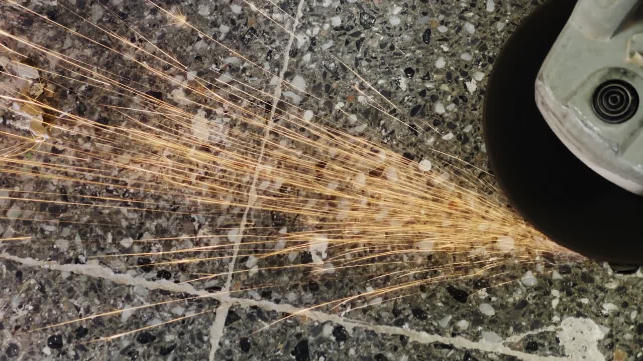 с помощью шлифовальной машины на каменной земле и искры