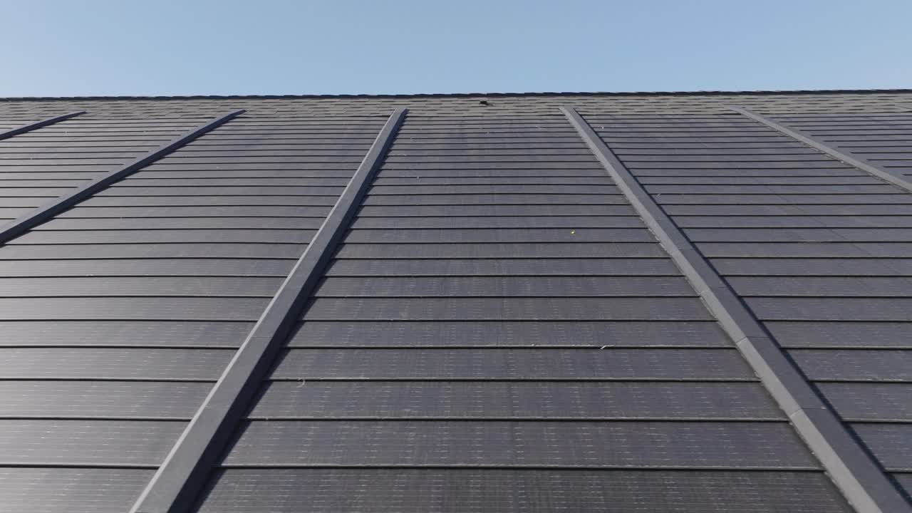 imágenes aéreas que muestran tejas solares instaladas en un moderno techo comercial.