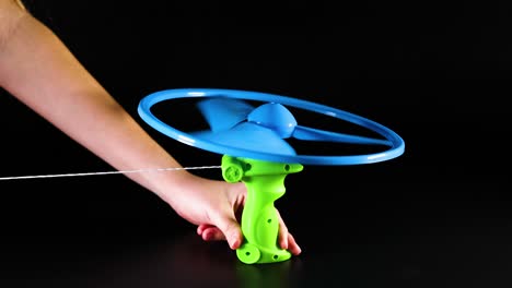 hand operating a pull string flying toy