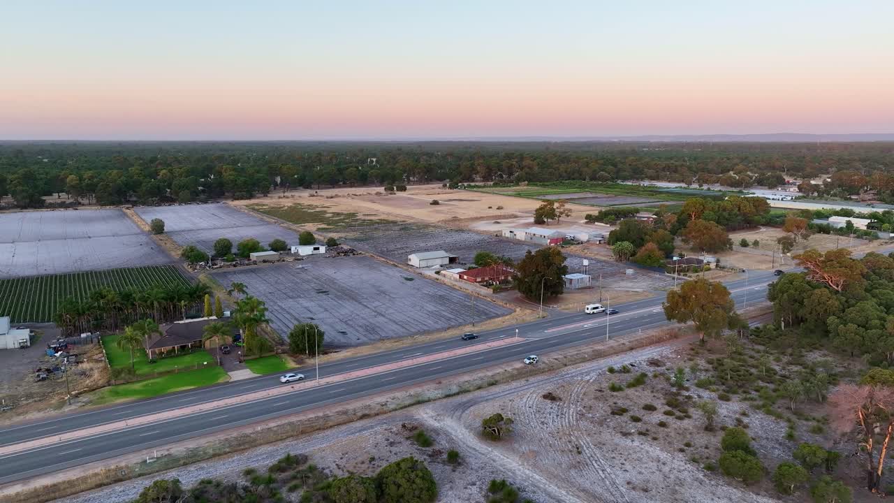 High angle drone view of countryside area with highways running across during sunset.