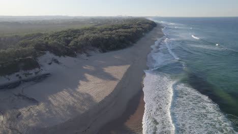foamy waves splashing on sandy shores of wurtulla beach in queensland, australia