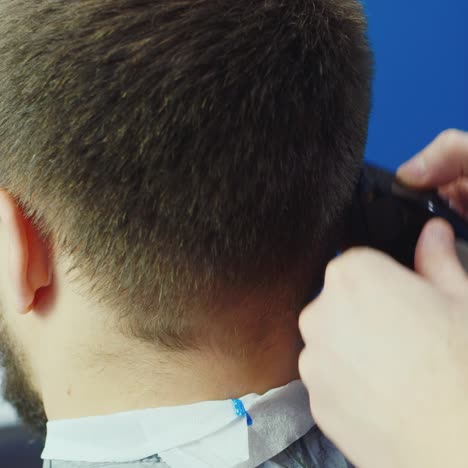 close up of barber trimming hair using clippers