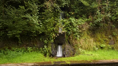 Wide-shot-of-Rainwater-being-funnelled,-controlled-under-the-platform-at-Cynonville-Station