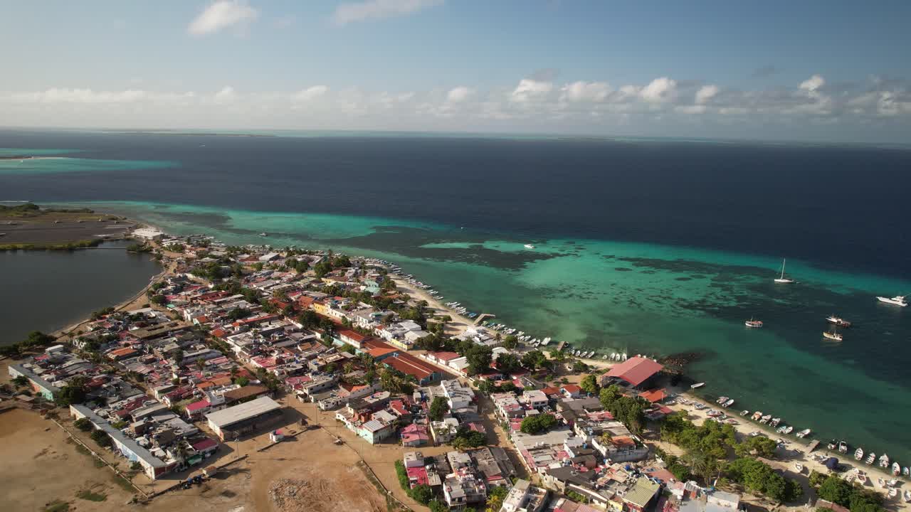 Colorful seaside town and turquoise waters in los roques under a sunny sky, aerial view