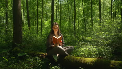 young woman reading a book in a sunlit forest