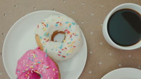 person taking from a breakfast table several delicious donuts and a cup of coffee