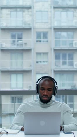 man working on laptop on a balcony